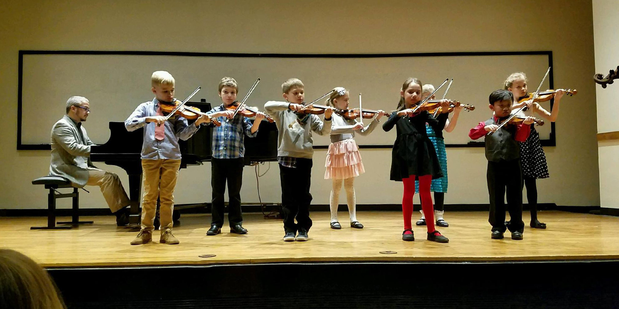 Children playing their violins.