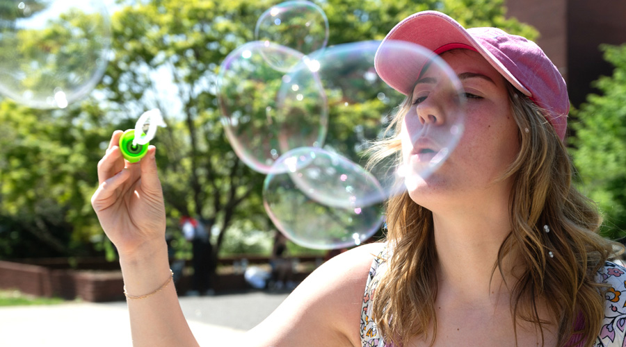 SIUE Student blowing a bubble on campus. 