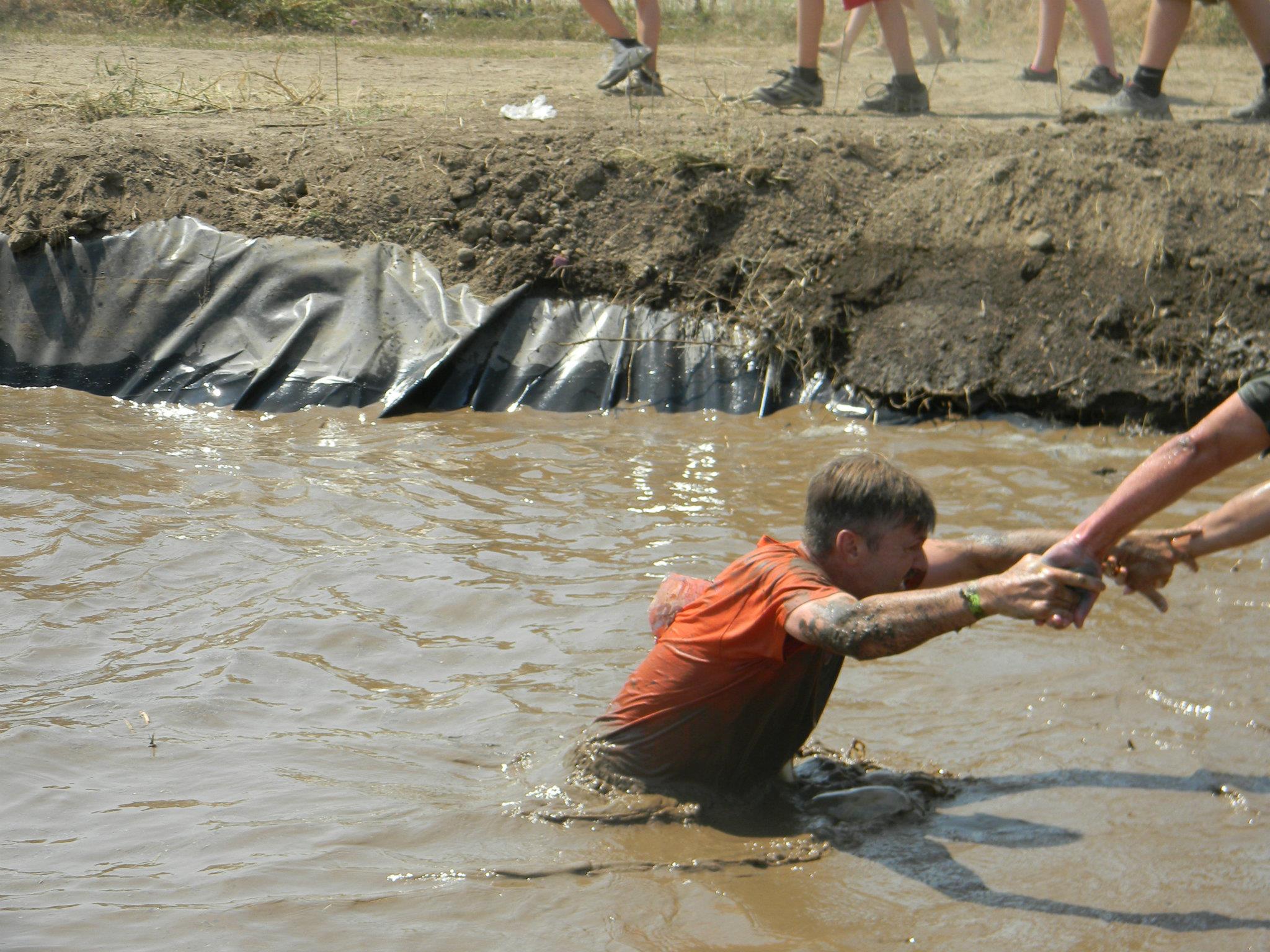 people helping a racer out of water